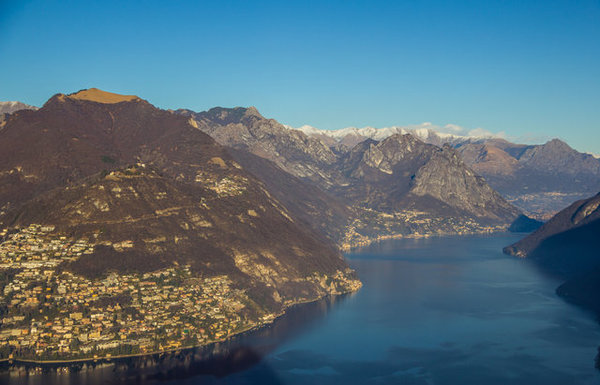 On top of the mountain there's a great observation area with 360 degrees view. Even more there's a small church of San Salvatore which dates back to 1414. During the summer time viewpoint on the roof of the church is open. On the photo there is the Monte Bre and Monte Boglia behind it and mostly Italian part of the lake Lugano. Lugano, Switzerland.